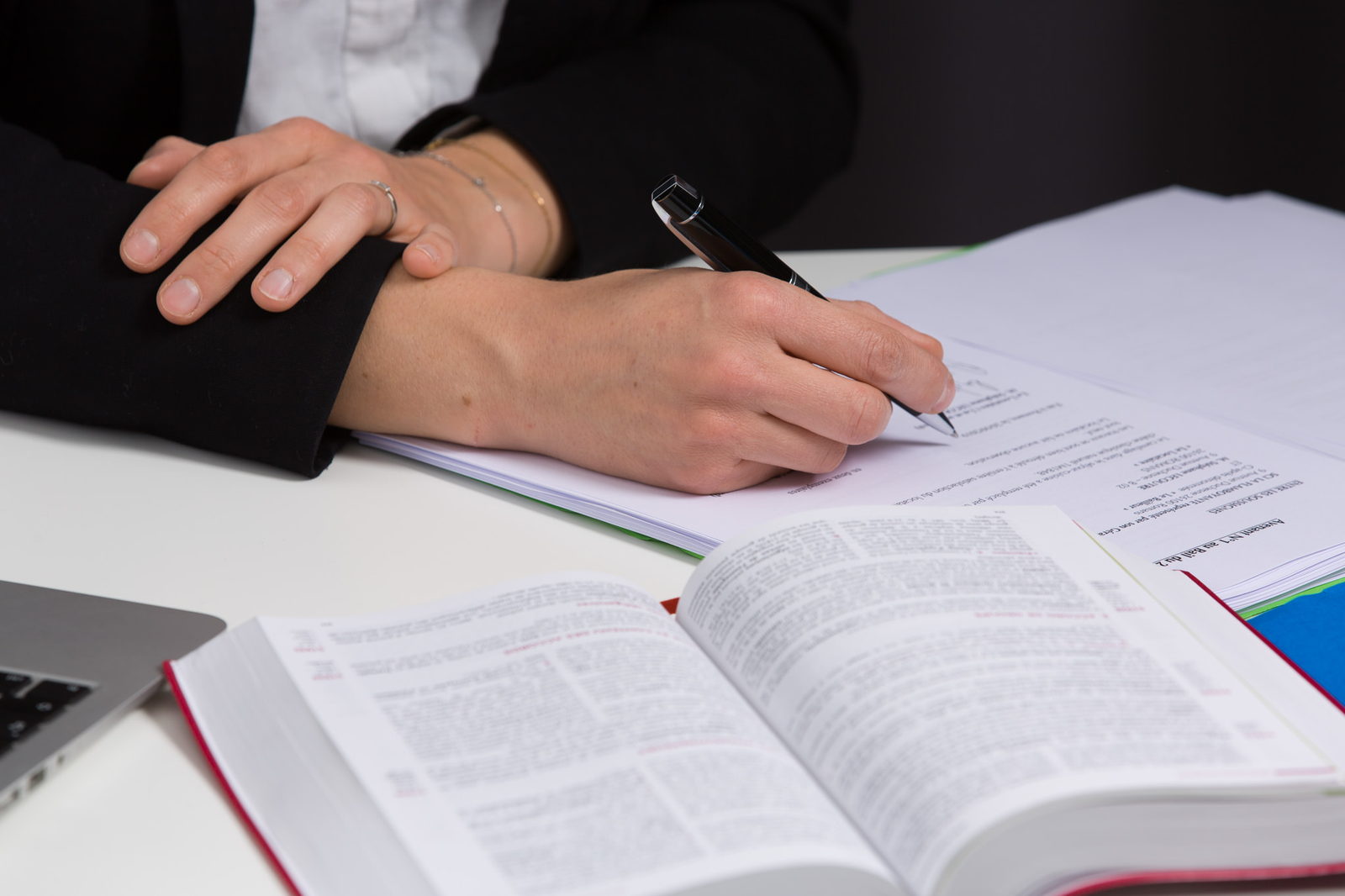 Mains d'une avocate annotant un code civil au stylo